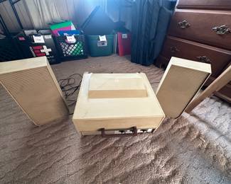 A vintage Montgomery Wards Portable stereo with attached speakers.