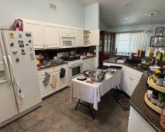 Kitchen full of gadget, cookware, dishes and flatware.