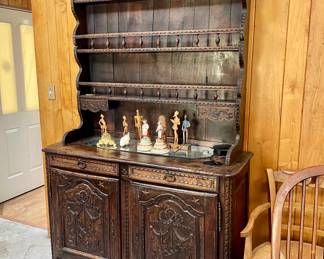 This is a French Provincial hutch,  crafted from oak, featuring detailed carvings and a traditional design.