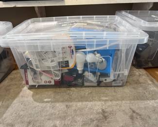 A lot with lightbulbs several sizes, smoke detectors extension cords, power adapters, a door knob, Cordless AT&T, telephone systems, Hammer heavy duty shears, Picture hanging supplies, charging cables and household wares