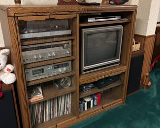 Oak entertainment filled with stereo equipment and albums
