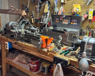 Metal lathe and tool box full of accessories to the lathe.