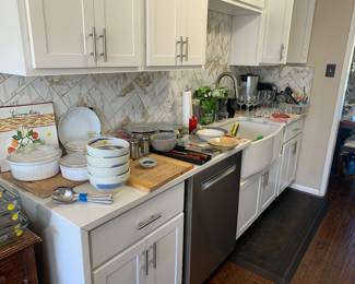 Lots of great kitchen stuff Including Pyrex, Corning Ware, Glassware, pots and pans, Single brew coffee maker, Lodge cast-iron skillet just to name a few