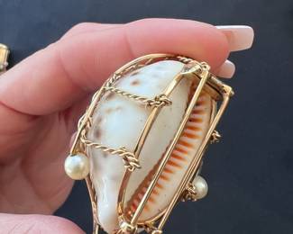 Shell caged in a custom 14kt gold and pearl design