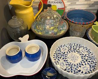 Kitchen full of quality dinnerware, stoneware, cookware, etc., including a Chantal red apple ceramic tray, and a Donna Johnston stoneware bowl.