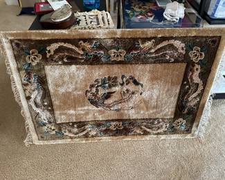 Silk rug on frame hangs on wall