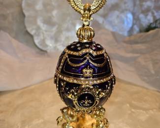 Large hollow metal and enamel purple egg box is 9" high. The eagle is attached magnetedly. On separate stand.