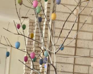 A large tree adorned with colorful eggs