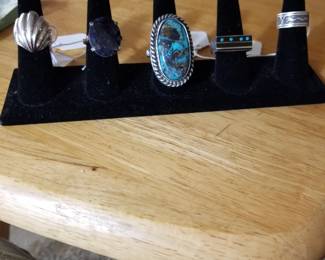 Selection of silver rings, including large Navajo in center.