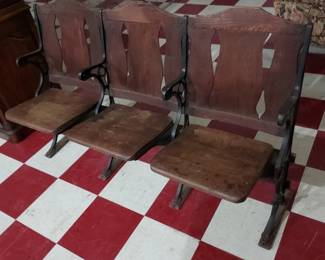 old west wooden 3 piece row of theater seats with racks underneath to hang your cowboy hat.  