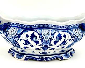 LOT 98 Register: www.woodardlipe.com ANTIQUE BLUE AND WHITE FAIENCE JARDINIERE, C. 1900, STAMPED Length 19 in, width 8.25 in, height 7.5 in, Hand Painted blue porcelain jardiniere with cherub/putti faces on each end. Stamped B, 301, T on the bottom.