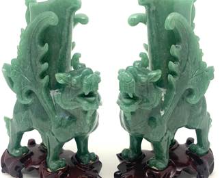 LOT 59 Register: www.woodardlipe.com PAIR HETIAN NEPHRITE SPINACH GREEN JADE FOO DOG VASES ON CARVED ROSEWOOD BASE Height 7.5 in, width 5 in,. width 2.25 in. Solid carved natural Nephrite winged Foo Dogs in opposite leaning head gestures. Pieces come with rosewood stand. 20th century.