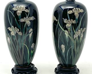 LOT 68 Register: www.woodardlipe.com PAIR JAPANESE BLACK CLOISONNE VASES WITH IRIS MOTIF MEIJI PERIOD JAPAN WITH WOOD STANDS Diameter 3 in, height 6.5 in. Lustrous black enamel finish with white and green iris flowers and leaves throughout the body of the vase. Copper interior and base and comes with stand.