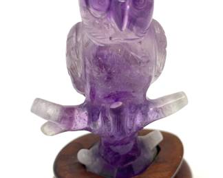 LOT 52 Register: www.woodardlipe.com AMETHYST OWL ON BRANCH ON ROSEWOOD STAND Length 2.5 in, width 2 in, height 4 in. with stand. Weight 100 grams with stand. One of the most popular crystal stones in the world, this amethyst owl is hand carved on rosewood base in the mid-century and features a beautiful lavender and white crystal.