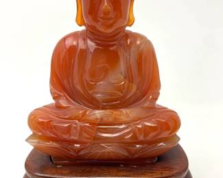 LOT 53 Register: www.woodardlipe.com CARNELIAN CRYSTAL FIGURE OF BUDDHA ON ROSEWOOD STAND Length 3 in, width 1.5 in, height 4 in. without stand. Weight 277 grams without stand. Finely hand carved mid-century figure of Buddha on a rosewood stand. Carnelian is a crystal known as the “artists stone” that boosts confidence and the power of true expression.