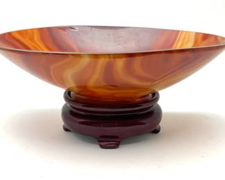 LOT 77 Register: www.woodardlipe.com RUST AGATE OVAL BOWL, QING DYNASTY, 18th / 19th CENTURY Length 6.25 in., width 4.25 in., height 1.75 in., Total weight 248 grams. Carved and polished agate bowl on wooden stand.