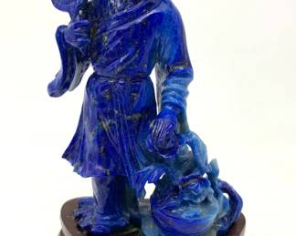 LOT 48 Register: www.woodardlipe.com LAPIS CARVED FIGURE HOLDING FAN WITH FLOWER BASKET Length 2.25 in, width 1.5 in, height 4.25 in, without stand. weight 121 grams. Exquisitely hand carved lapis lazuli figure of with flower basket on removable rosewood stand. Lapis lazuli is high-quality, deep blue and only found in limited quantities mostly in Afghanistan and is used for art and jewelry.