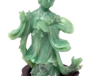 LOT 79 Register: www.woodardlipe.com CARVED SAGE GREEN JADE KWAN YIN WITH FLOWERS AND FLOWING SHAWL Height 5.25 in., 4.25 in., depth 2.0 in., Mineral weight 298 grams.