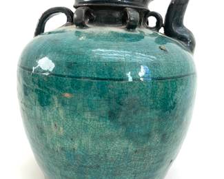 LOT 99 Register: www.woodardlipe.com CERAMIC CHINESE WINE JUG, C. 1900, HUNAN PROVINCE, CHINA Diameter 10 in, height 10 in. Traditionally used for storing rice wine, this large ceramic turquoise glazed jug with crackling and age around the neck. Black stone bottom. It features an opening and spout with four small rings around the opening.