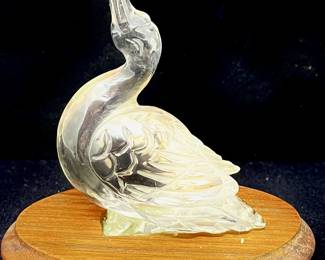 LOT 73 Register: www.woodardlipe.com CARVED CLEAR QUARTZ DUCK ON WOOD BASE Height 3.25 in., length 3 in., depth 1.25 in, Mineral weight 91 grams. Polished quartz sculpture of duck with elevated beak.