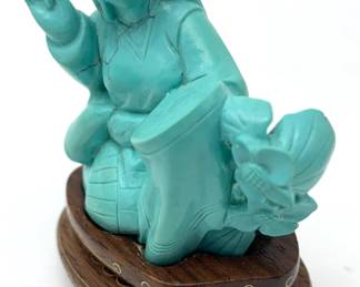 LOT 49 Register: www.woodardlipe.com HAND CARVED TURQUOISE SEATED WOMAN SEWING Length 2.5 in, width 1 in, height 2.25 in. Weight 89 grams. Chinese hand-carved figure of a woman sewing on removable rosewood base with brass inlay detail. The turquoise stone has many meanings, including good fortune, protection, emotional balance and stress relief.