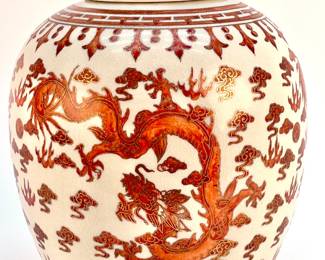 LOT 160 Register: www.woodardlipe.com CHINESE PORCELAIN LIDDED DRAGON GINGER JAR, 20TH CENTURY Height 13 in., diameter 9 in., Modeled and designed after the red dragon and phoenix pattern from the Qing Dynasty, the jar is a classic temple jar, characterized by its rounded body and lid. Symbols of power and prosperity, the motifs are set against a white background with additional floral patterns.