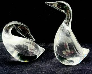 LOT 24 Register: www.woodardlipe.com PAIR OF STEUBEN CRYSTAL GLASS GEESE FIGURINES, STANDING AND PREENING Height 5.25 in, 3.5 in, length 3 in, 4 in, depth 2 in, 2 in. Pair of crystal geese, one standing with neck outstretched and the other preening its feathers, these figures are excellent examples of the beautiful clear glass for which Steuben is known. Both are etched Steuben on the underside.