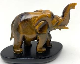 LOT 30 Register: www.woodardlipe.com CHINESE CARVED TIGER EYE FIGURE OF ELEPHANT Length 3 in., height 2.5 in., width 1.5 in.; total weight with base 130 grams. Considered the universal luck stone and in some systems is reputed to attract money. Elephants are associated with wisdom, strength, protection, and luck. Bloodstone is said to have grounding energies and can help increase courage, vitality, and emotional balance.