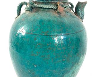 LOT 100 Register: www.woodardlipe.com CERAMIC CHINESE WINE JUG WITH ROPE, C. 1900, HUNAN PROVINCE, CHINA Diameter 10 in, height 11 in. Traditionally used for storing rice wine, this large ceramic turquoise glazed jug with crackling and age around the neck. It features an opening and spout with four small rings around the opening with a rope encircling the opening.