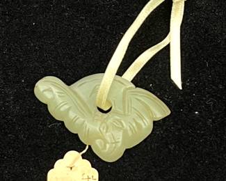LOT 121 Register: www.woodardlipe.com ANTIQUE CHINESE JADE PENDANT Length 2 in, width 1.25 in. White jade hardstone pendant with center hole is carved with antique candle wax stamp on the back.