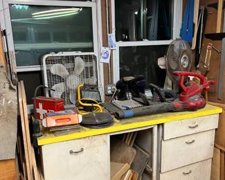 Under the tabletop here is a large collection of various homemade jigs and sleds.  On top, a couple of fans, a leaf blower, and other pieces.  Look on the sides here, and you'll find T-squares, router circle tools, and more.