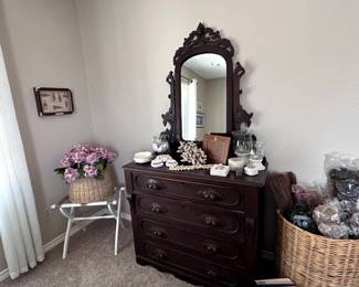 Antique dresser with ornate mirror. Dries and silk flowers for decor.