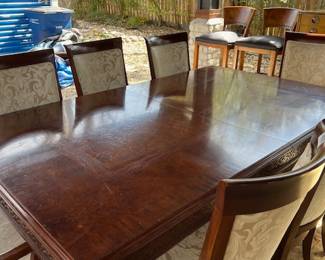 Burled wood dining table with 8 upholstered chairs.