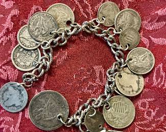 Various silver coins, charm bracelet