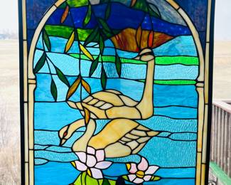 Handcrafted stained glass window panel with swans in water 