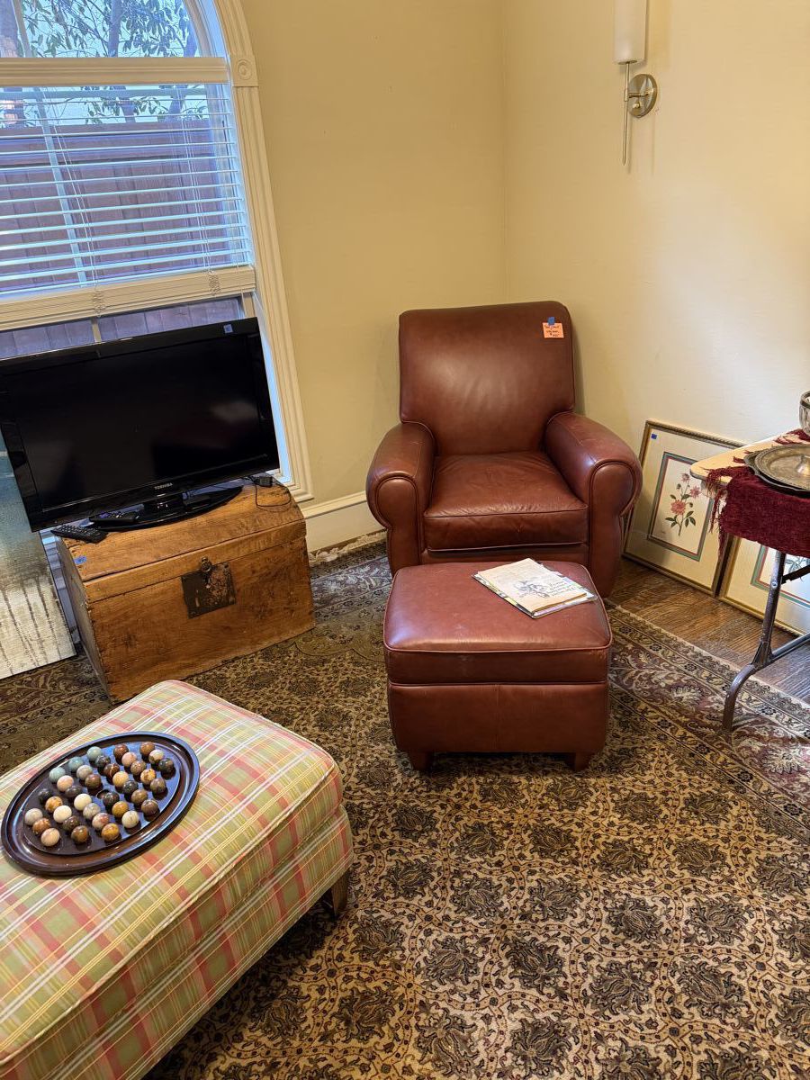 leather chair with ottoman. Old wooden chest. Roku TV.