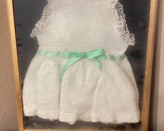 Vintage knitted baby clothes in shadowbox