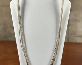 A Navajo liquid silver necklace measuring 29” in excellent condition. Marked 925 on either side with a total approx. weight of 63.81 grams. Liquid silver is a term used to describe several strands of small silver beads held together to create a fluid-looking piece. It is created by slicing tubes of Sterling Silver and then stringing them together carefully. This type of jewelry is often also known as liquid heishi or silver heshi.