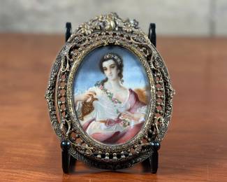 An antique French signed miniature portrait in gilt frame, circa late 19th century. Signature present on right side of portrait as shown in photos. Likely from the Victorian era, this antique French portrait miniature features a young woman beautifully painted and covered with glass. The back of the frame is marked and appears to be made in the Czechoslovakia. Czechoslovakia was a country in central Europe that was made up of Bohemia, Moravia, and Slovakia. It was formed in 1918 after World War I when Austria-Hungary collapsed. In 1993, Czechoslovakia peacefully split into the Czech Republic and Slovakia. This portrait measures in the frame, 5.25” H x 4.25” W.