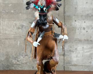 A large Kachina doll titled, “Broad Faced” by listed artist, Billy Begay. Begay is known for Native American art. This work of art is titled and signed on the bottom as shown in photos. This Kachina measures 20” H x 9” W x 7” D.