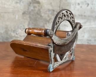 A 19th century baker bread slicer with a handwritten note giving provenance back to the late 1800s. The iron handle boasts a wonderful pierced Art Nouveau design and the blade is marked with the number “2”. This bread slicer (when folded down), measures 10” H x 12” W x 14” D.