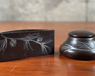 An antique inkwell and blotter manufactured by Heintz Art Metal Shop circa 1912. Sterling and bronze with maker mark present underneath as shown in photos. Otto L. Heintz was the founder of the company. He was born in 1877 into a family of jewelers and set out on his own in 1902 when he took over a small local business, renamed it the Art Crafts Shop, and began creating copper pieces with colorful enamel decoration.