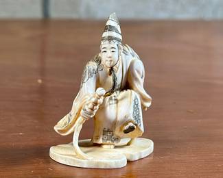 An antique fine carved Oriental Netsuke in good condition and signed underneath as shown in photos. A netsuke is a miniature sculpture, originating in 17th century Japan. Initially a simply-carved button fastener on the cords of an inrō box, netsuke later developed into ornately sculpted objects of craftsmanship. This Netsuke measures 2” H x 2” W x 2” D.