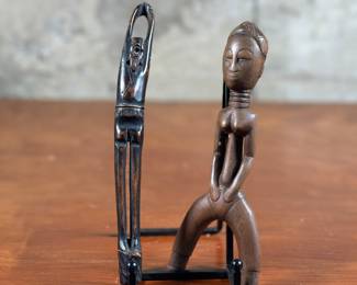 A Japanese pipe holder & an African slingshot sculpture. The pipe holder was most likely for Opium. Kiseru (煙管) is a Japanese word that refers to a traditional smoking pipe. It is used to smoke finely shredded tobacco called kizami. African slingshot sculptures are hand-carved wooden figures that are often associated with the Baule carving culture of Ivory Coast. They are figurative objects that can depict heads or bodies. The tallest measures 8” H.
