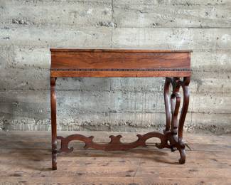 A beautiful antique European Rosewood flip top writing desk. Some minor wear throughout, but in good condition overall. The top folds back with a removable felted cover. This piece measures 28.5” H x 33.5” W x 17.25” D.