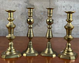 Two pairs of vintage brass candlestick holders in good condition (some wax present). The taller pair measures 11” H x 3.5” W x 3.5” D.