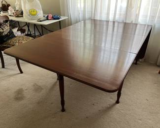 Double drop leaf dining table with leaves and table pads.