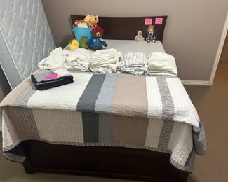 Full-size trundle bed with linens and kids stuffed animals