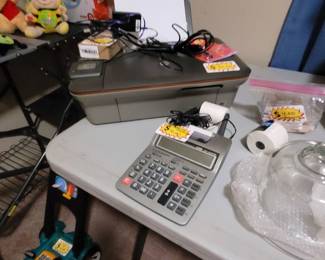 Desktop printer with paper and ink; calculator with paper. 