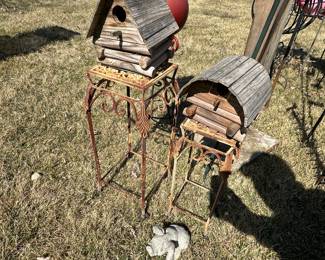 Two nice wooden birds houses sitting on two sweet little vintage metal display tables! 